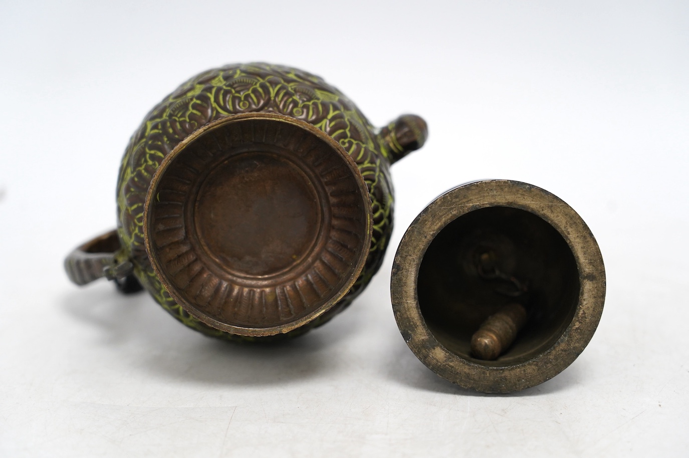 A 19th century Tibetan bronze ghanta bell and a 19th century Tibetan repousse copper teapot, tallest 18cm. Condition - fair to good